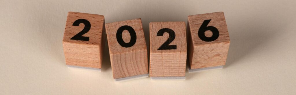 Wooden cubes forming the year 2026 on a neutral background.